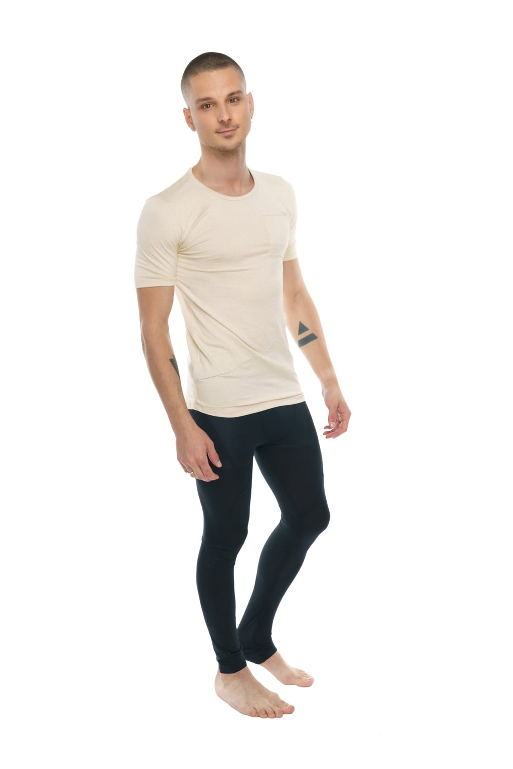 A man wearing a cream-colored perfect pocket crew-neck tee with short sleeves and black leggings