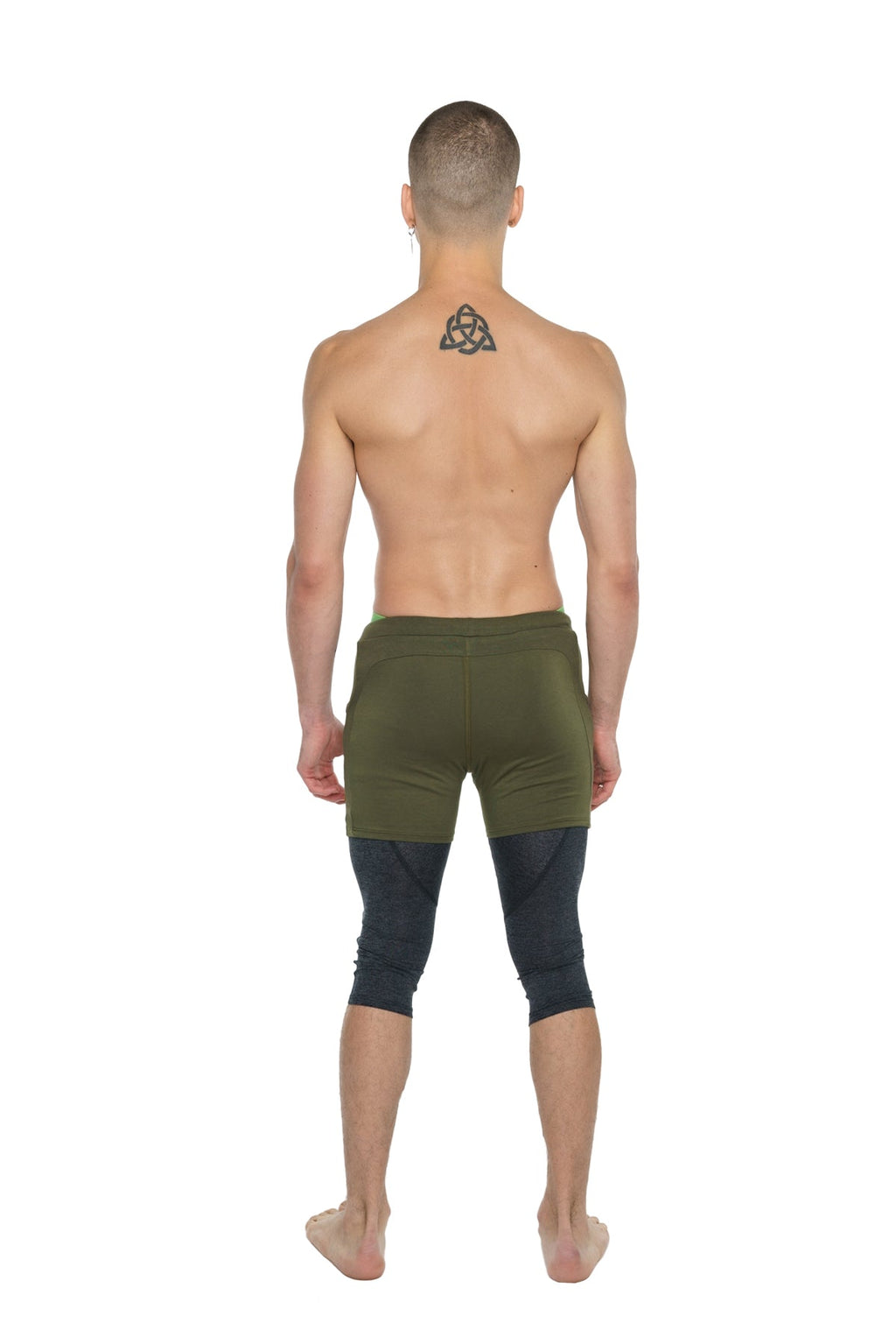 Performance yoga leggings 3/4 in charcoal heather worn under olive green athletic shorts for enhanced support and comfort