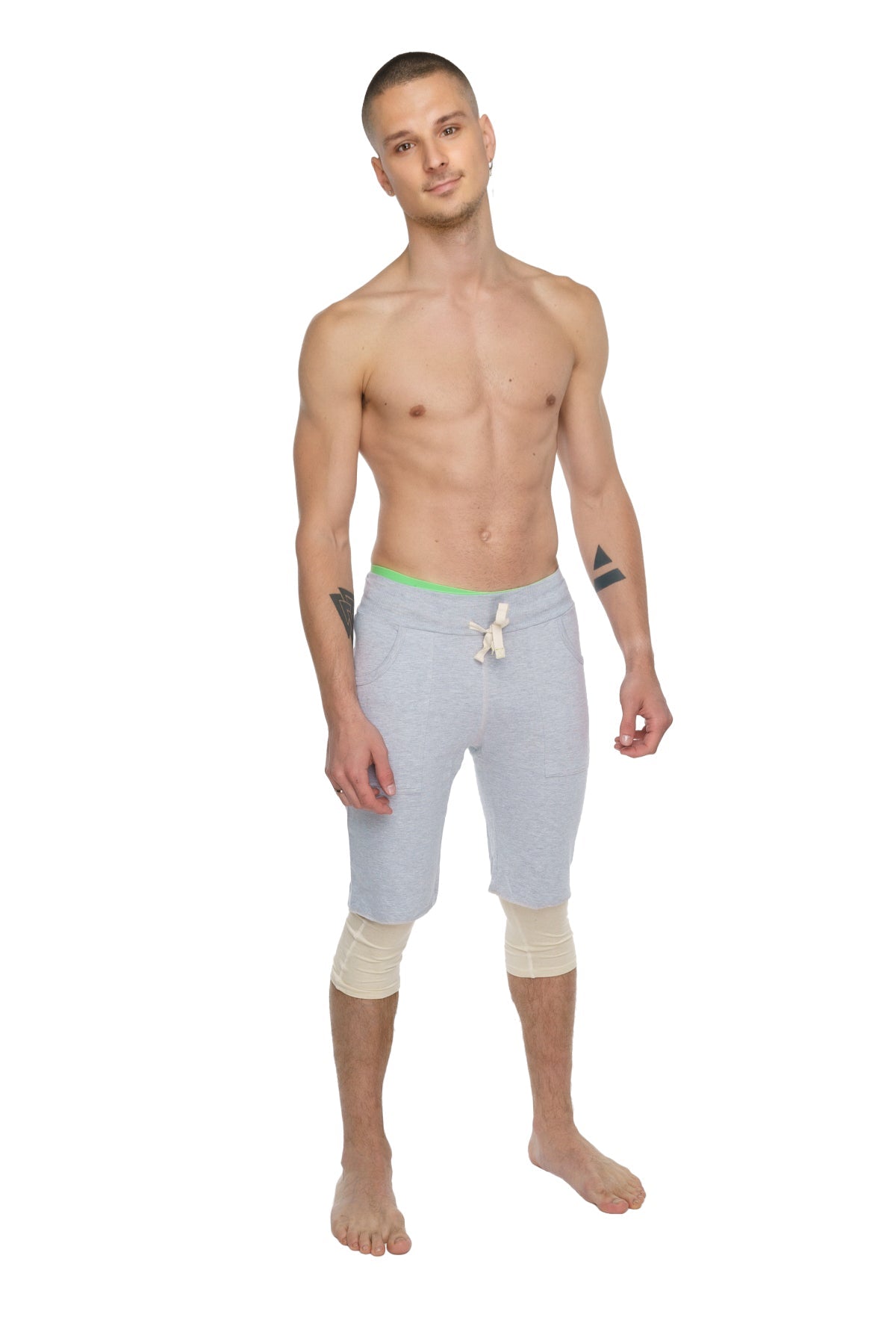 Performance yoga leggings 3/4 in sand beige with light gray athletic shorts featuring neon green waistband and white drawstring