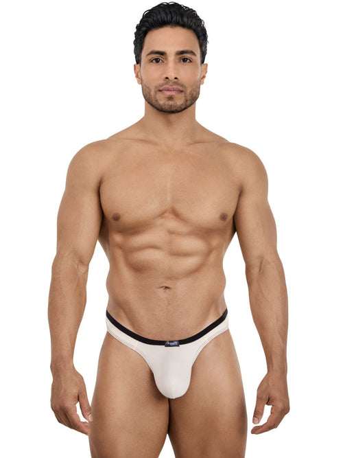A man modeling Pikante Isis beige thong underwear with a black waistband, featuring a minimalist, form-fitting design.
