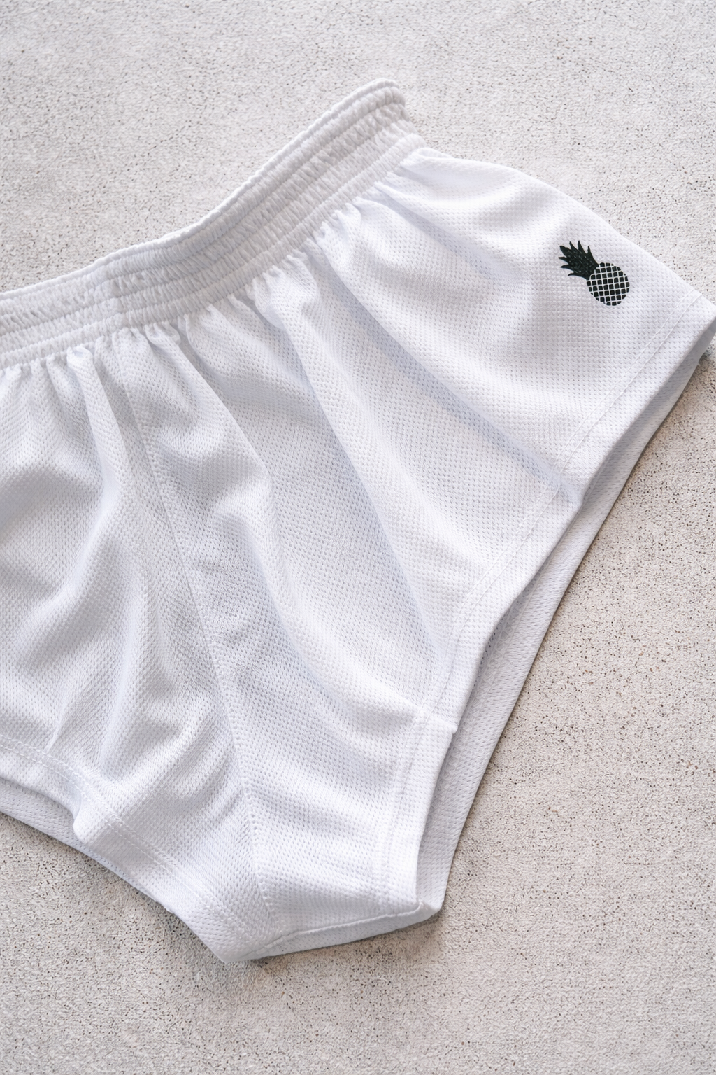 White mesh stretch-it 2 quick-dry athletic shorts with black pineapple logo embroidered on the side