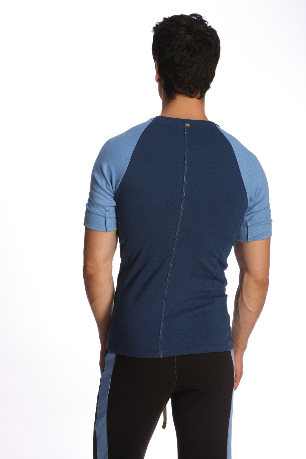 Back view of a royal blue and light blue raglan virtual crew neck athletic shirt with a central zipper down the back