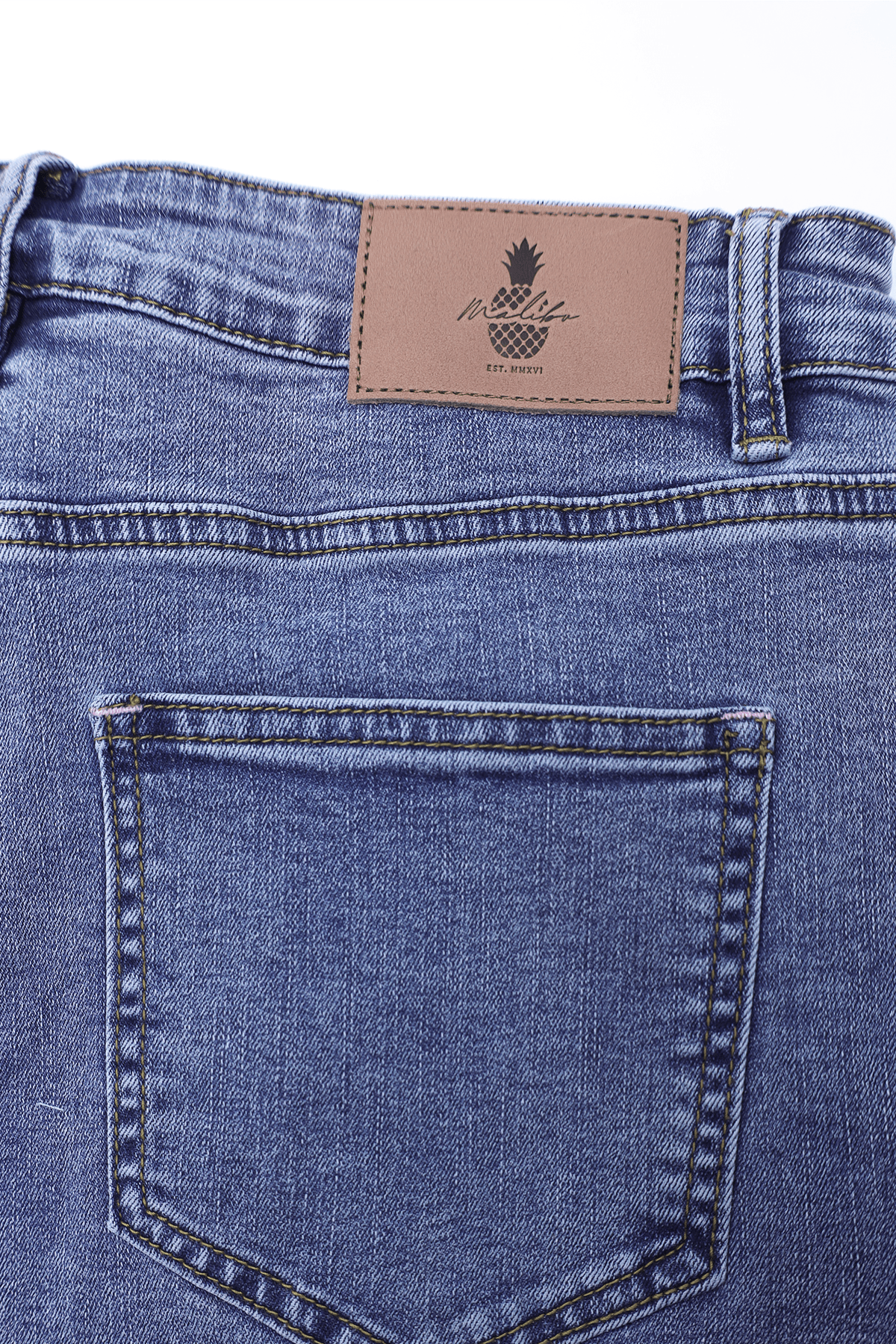 Blue denim rockstar raw cut 2.5 inch short shorts with brown leather patch featuring pineapple logo and mcllif branding