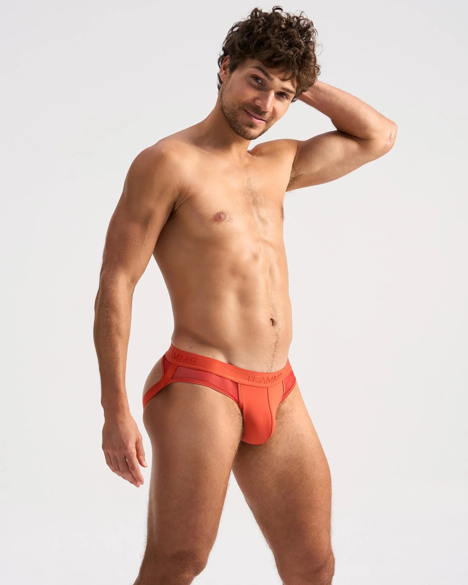 Bright orange sheer jock briefs with a sleek modern design and subtle branding on the waistband