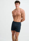 A man wearing ST33LE textured mesh stretch performance shorts in dark gray with an elastic waistband.