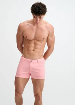 A shirtless man wearing pink ST33LE 3" stretch knit shorts with belt loops and a front button closure.