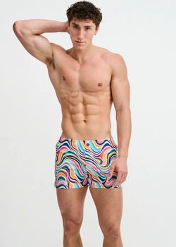 Model wearing ST33LE Swirls Printed Swim Short in teal and multi swirl pattern.