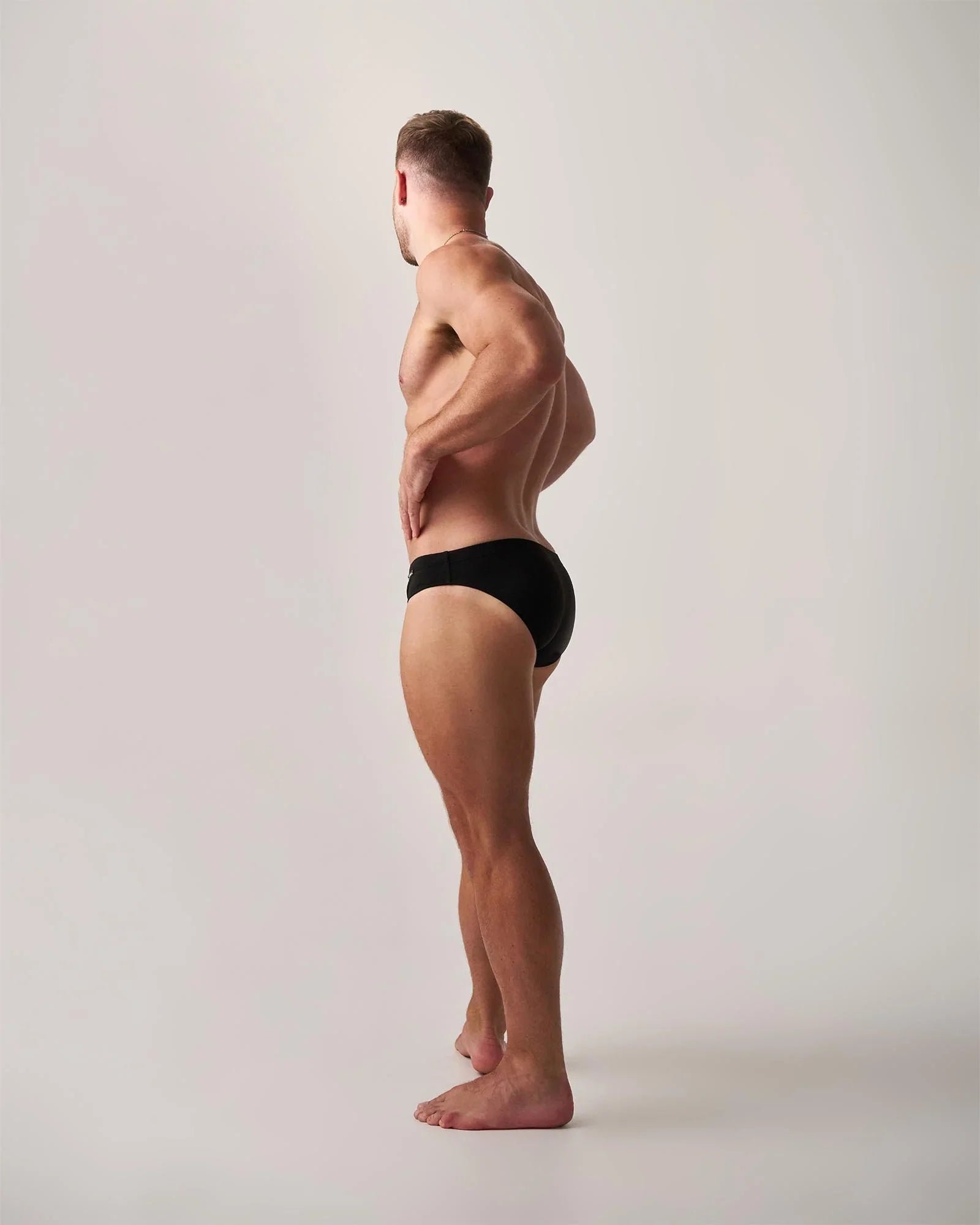 Black statement swim brief showing the back side in a sleek design for comfortable swimming and beachwear