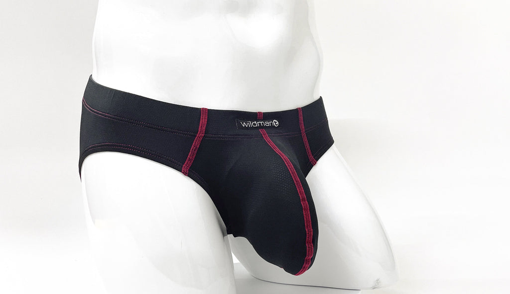 Black pouch brief with red contrast stitching and Wildman logo on the waistband, shown on a white mannequin.