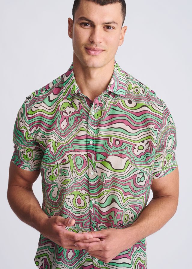 A vibrant short-sleeved button-up shirt with psychedelic green pink and white swirls in lightweight cotton silk