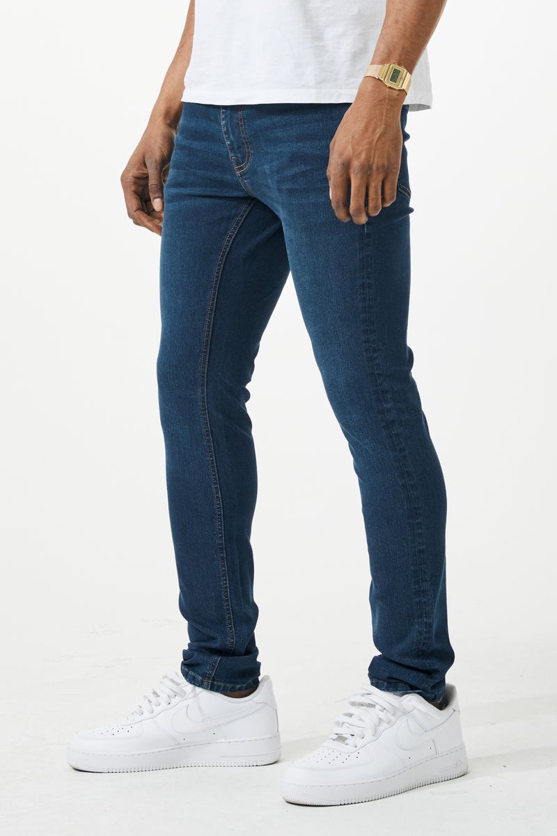 Dark blue skinny fit denim jeans with slim fit, five-pocket design, and subtle fading along the thighs