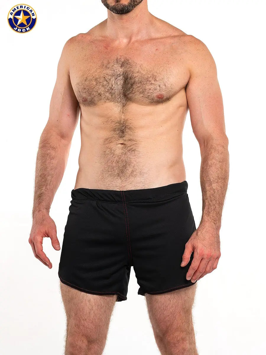 Black workout shorts with built-in jockstrap featuring a comfortable waistband shown on a model by AMERICAN JOCK.