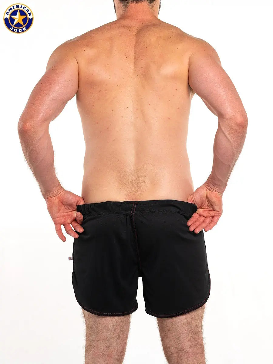 Black workout shorts with built-in jockstrap shown from the back on a male model by AMERICAN JOCK.
