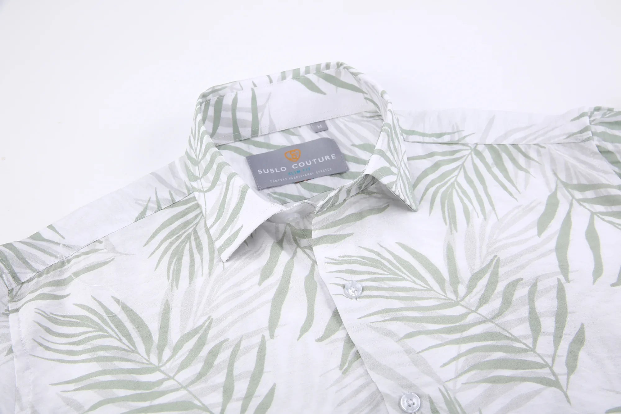 A white summer rain s s shirt with subtle green palm leaf pattern and suslo couture label at the collar