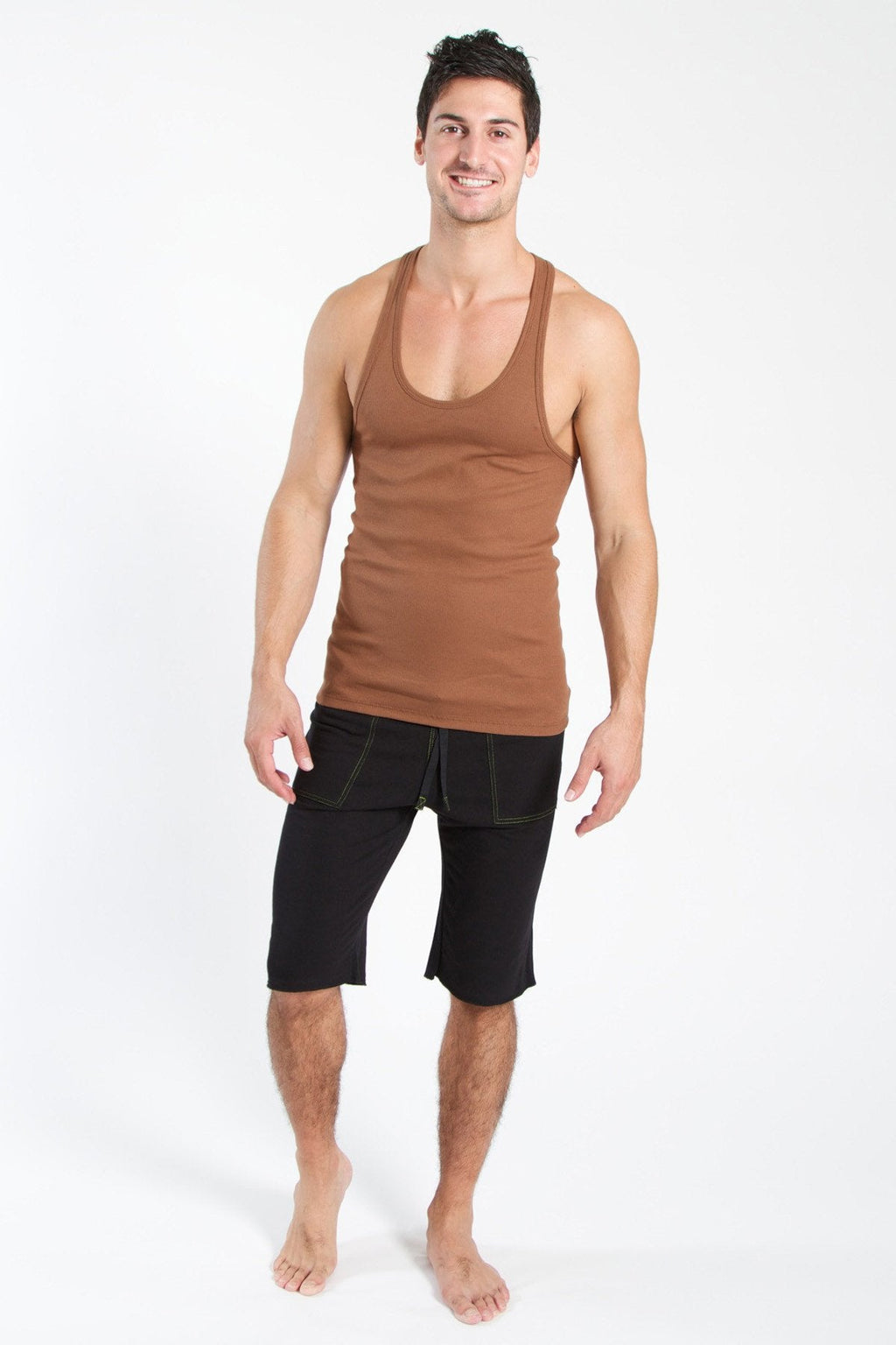 A man wearing a chocolate brown sustain tank top with scoop neckline and black shorts for casual wear