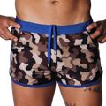 Camo print swim shorts with a blue elastic waistband, matching drawstring, and blue trim detail on a black background.