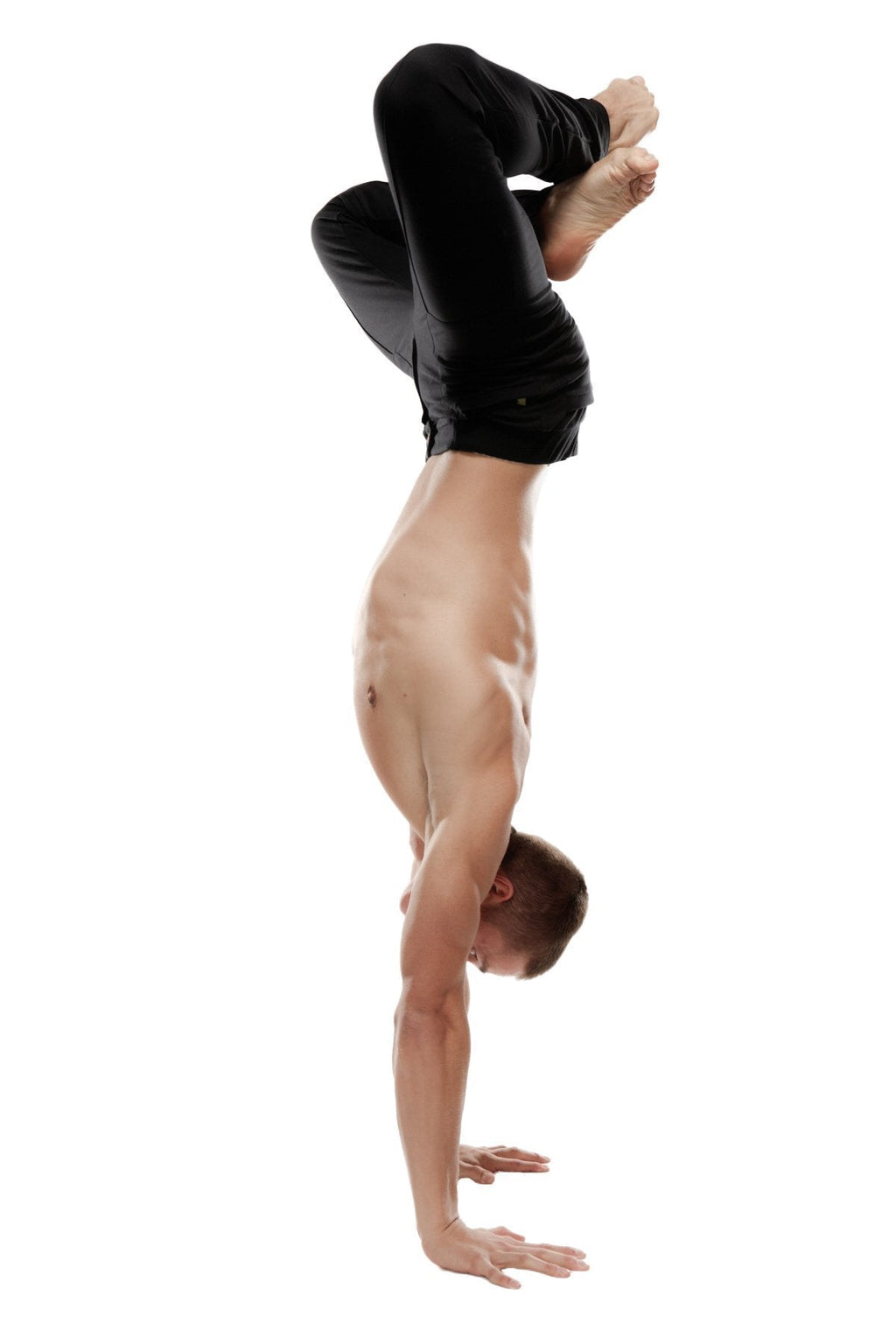 A shirtless man performs a handstand wearing black tactical urban at home dress pant yoga pants designed for comfort and flexibility