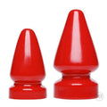 Two vibrant red glossy plastic anal plugs with tapered tips and rounded bases from the anal destructor series