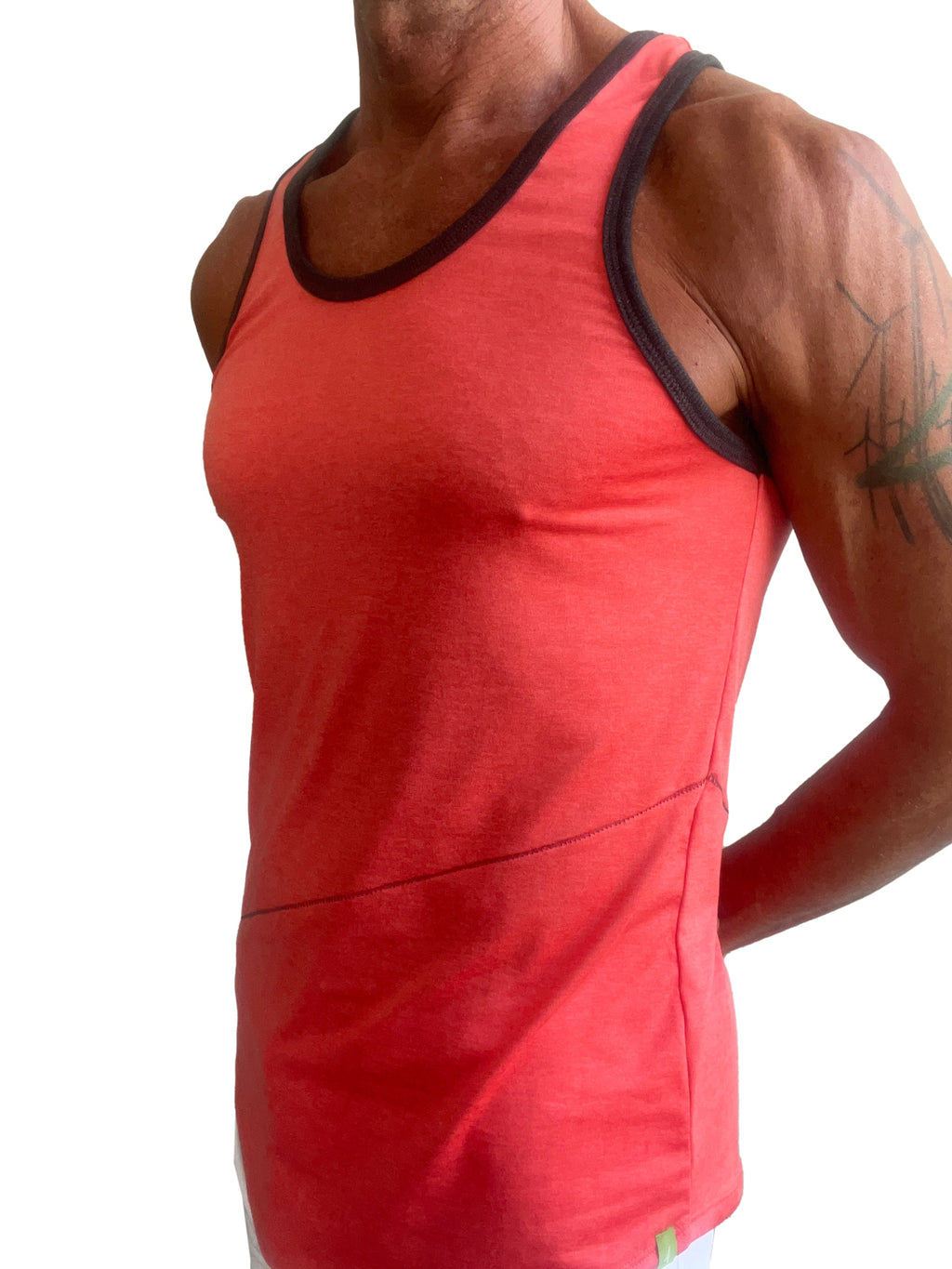 A vibrant coral-red tank top with black trim and subtle side seam detail called the perfect tank coral