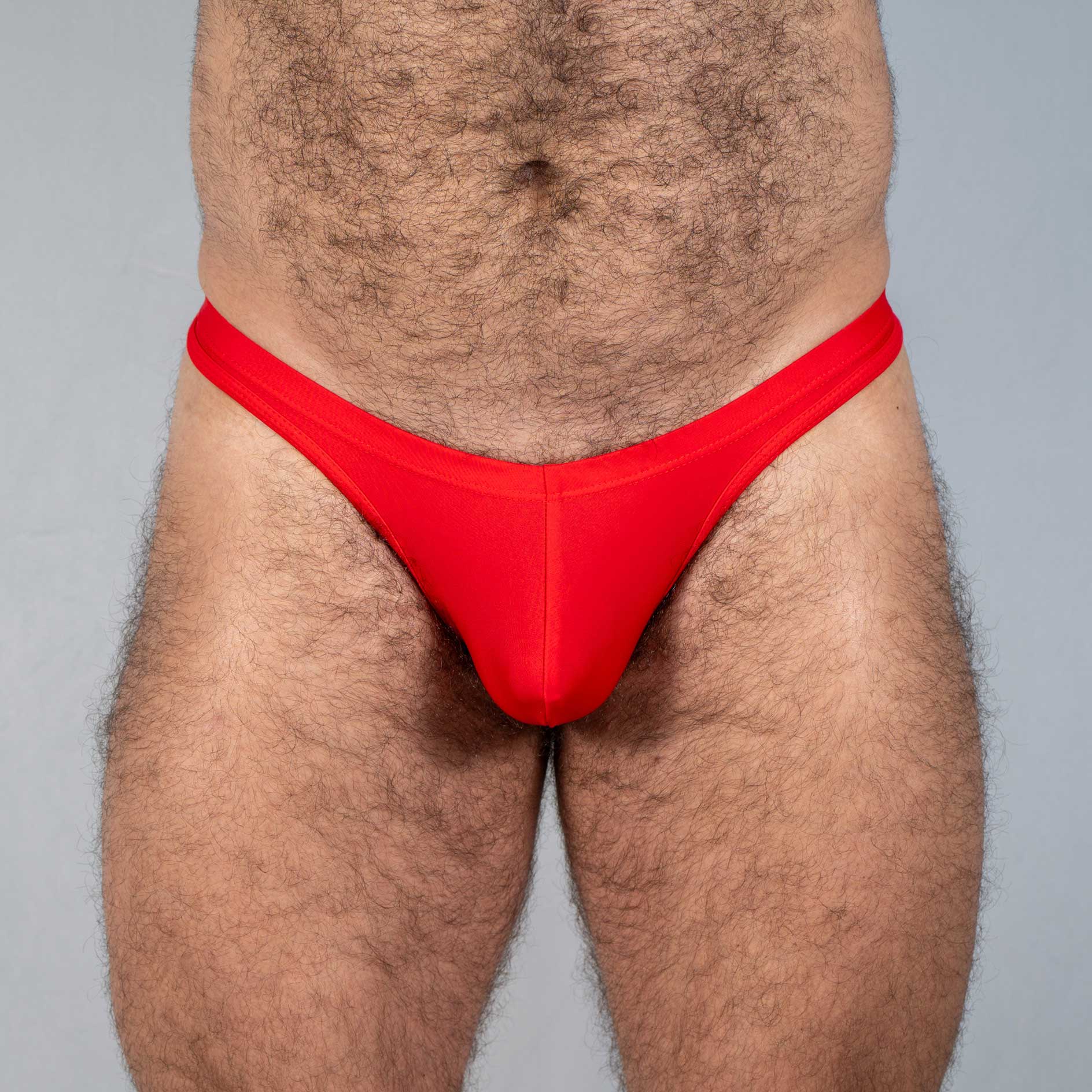 Bright red tulio swim thong made of smooth stretchy fabric with a form fitting design for comfortable swimwear use