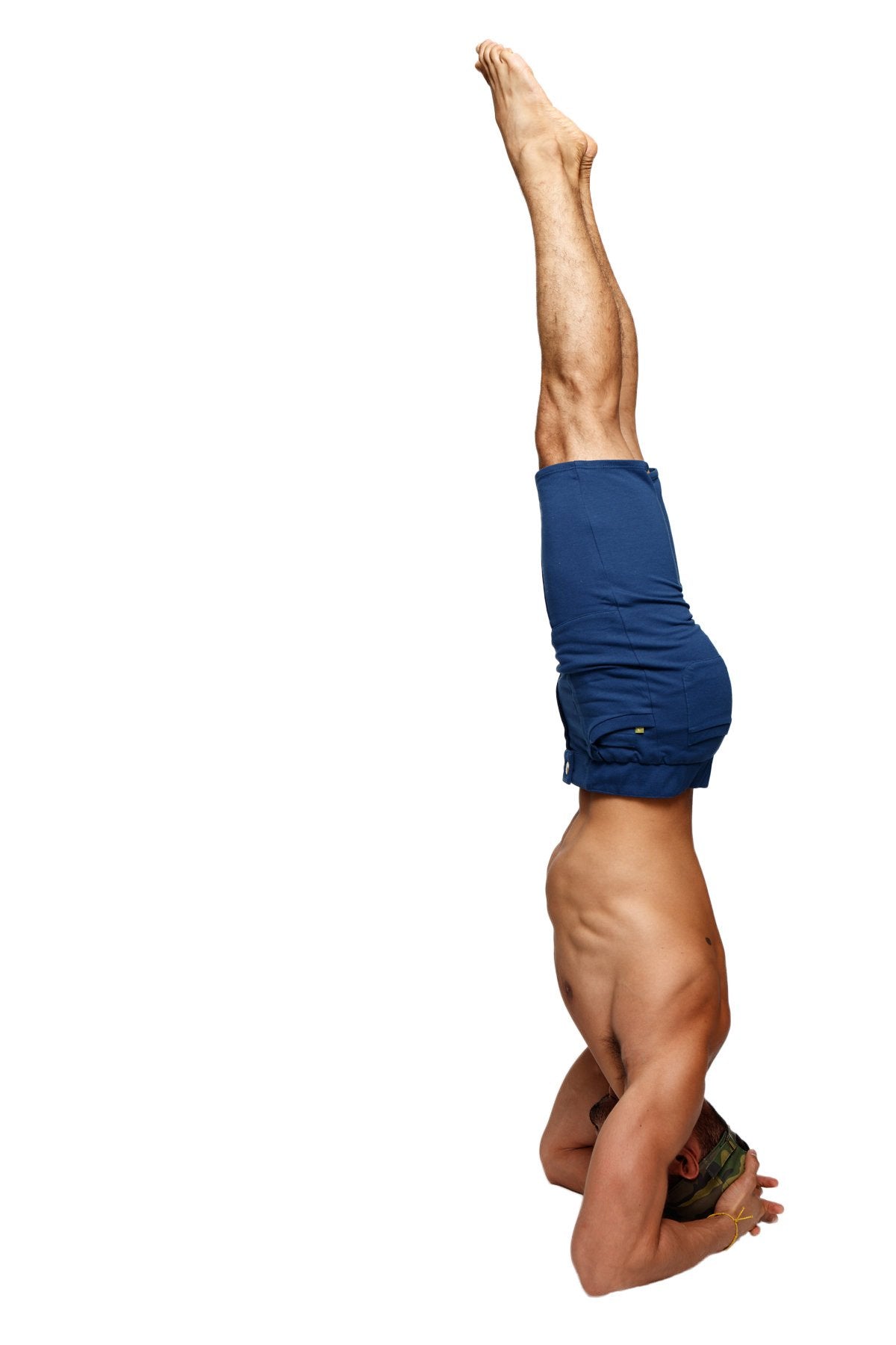 A muscular man wearing royal blue urban tactical at home dress shorts performing a headstand