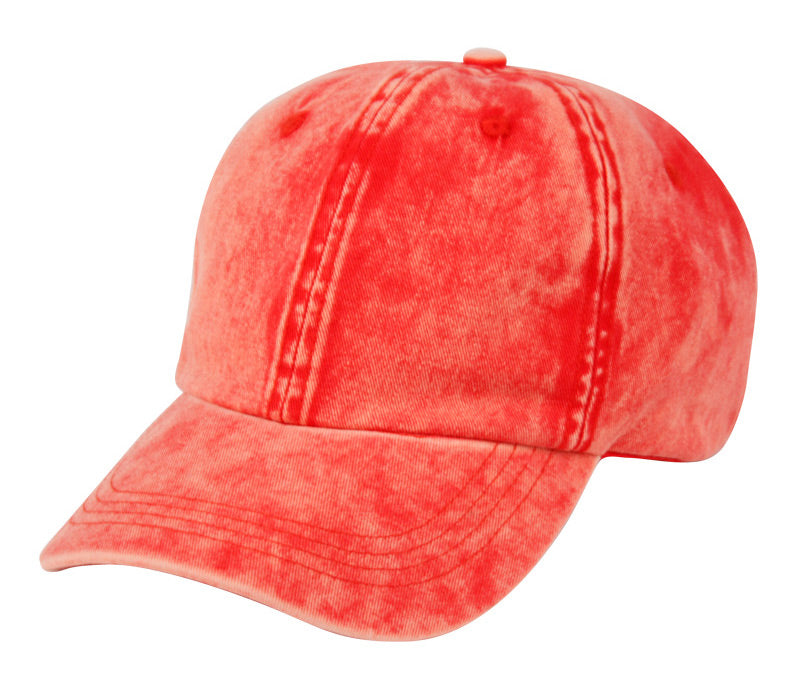 A coral-colored distressed denim baseball cap made of washed cotton with visible stitching and a matching top button