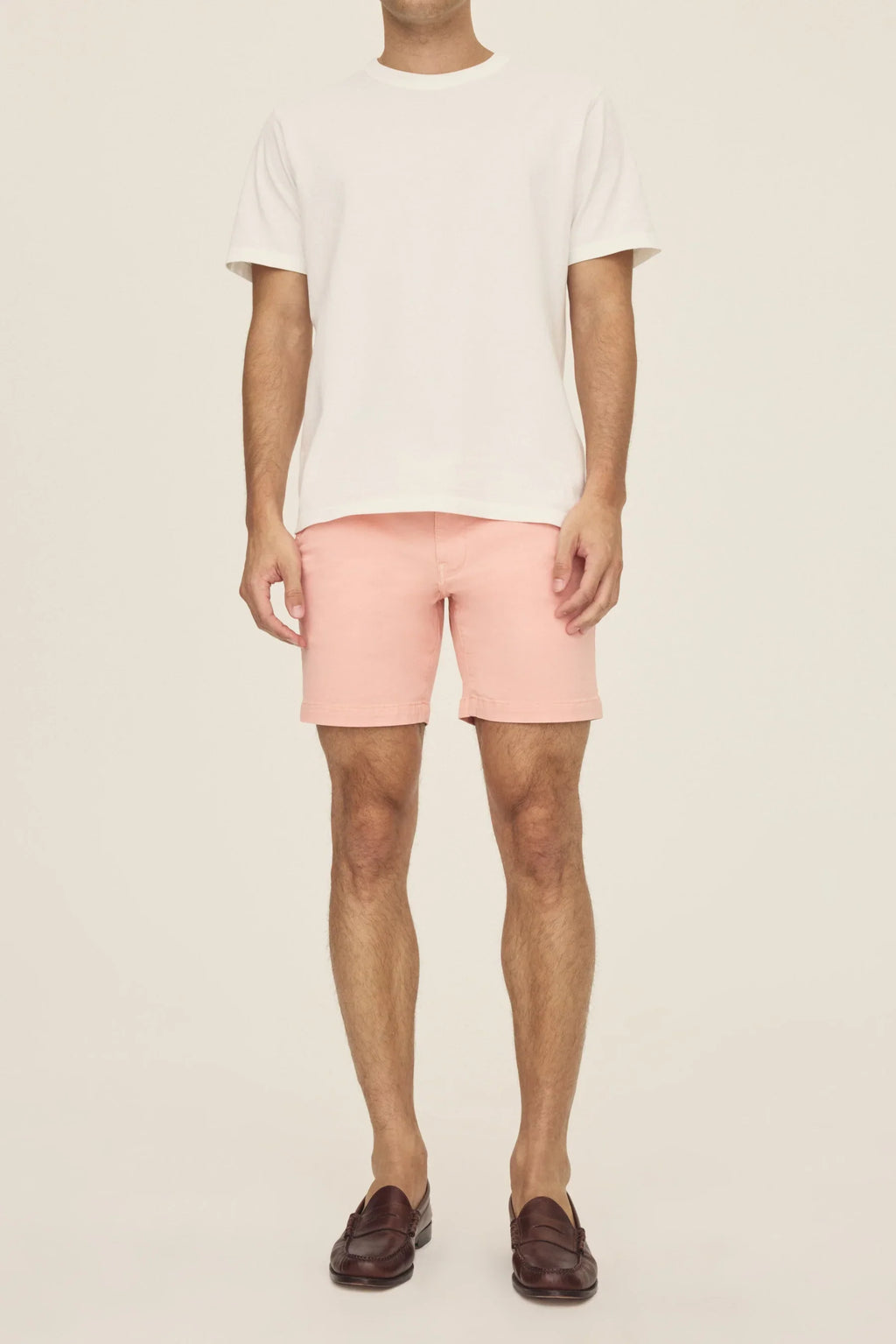 Warp + Weft Denim Act Chino Shorts in pink worn with a white t-shirt and brown loafers.