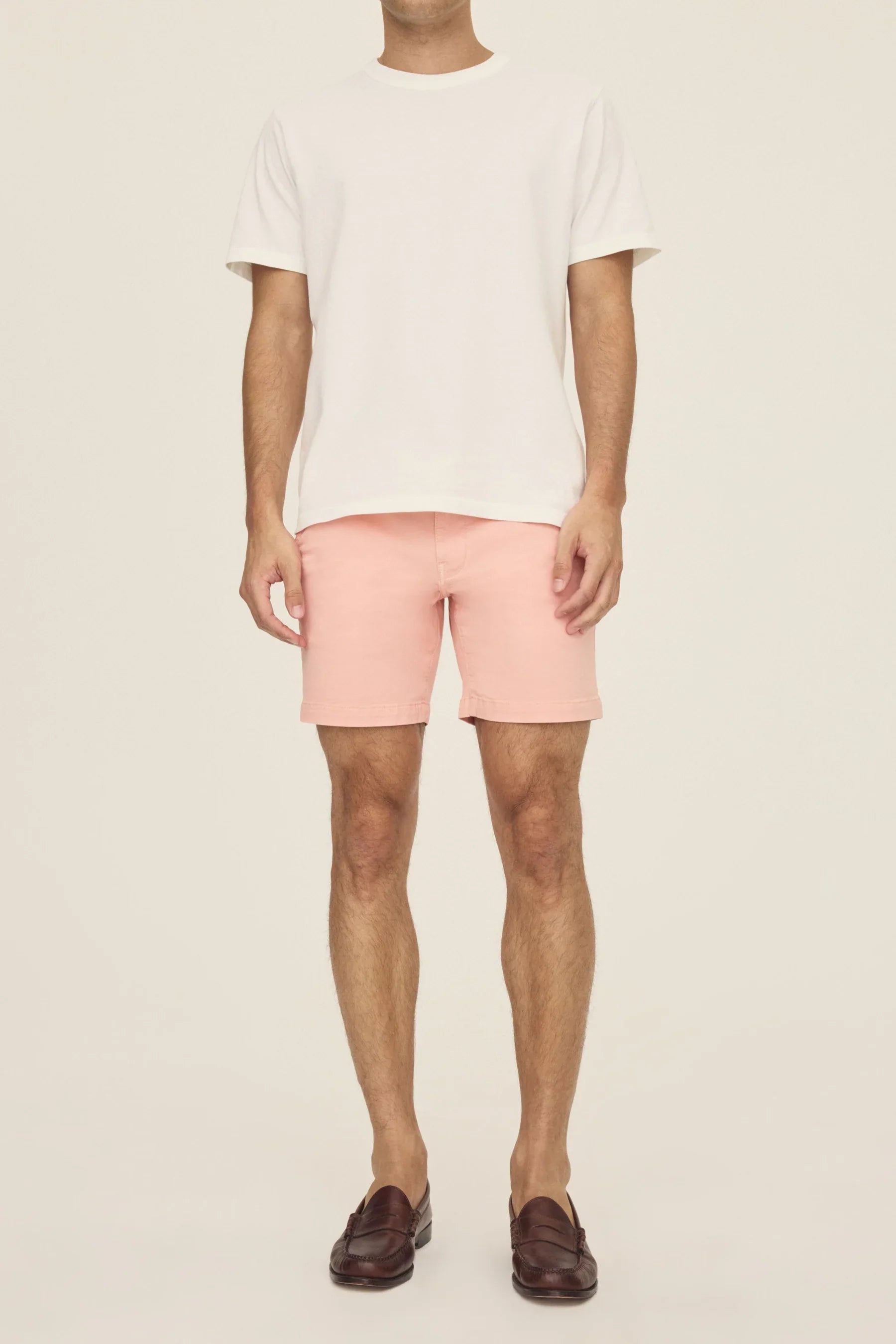 Warp + Weft Denim Act Chino Shorts in pink worn with a white t-shirt and brown loafers.