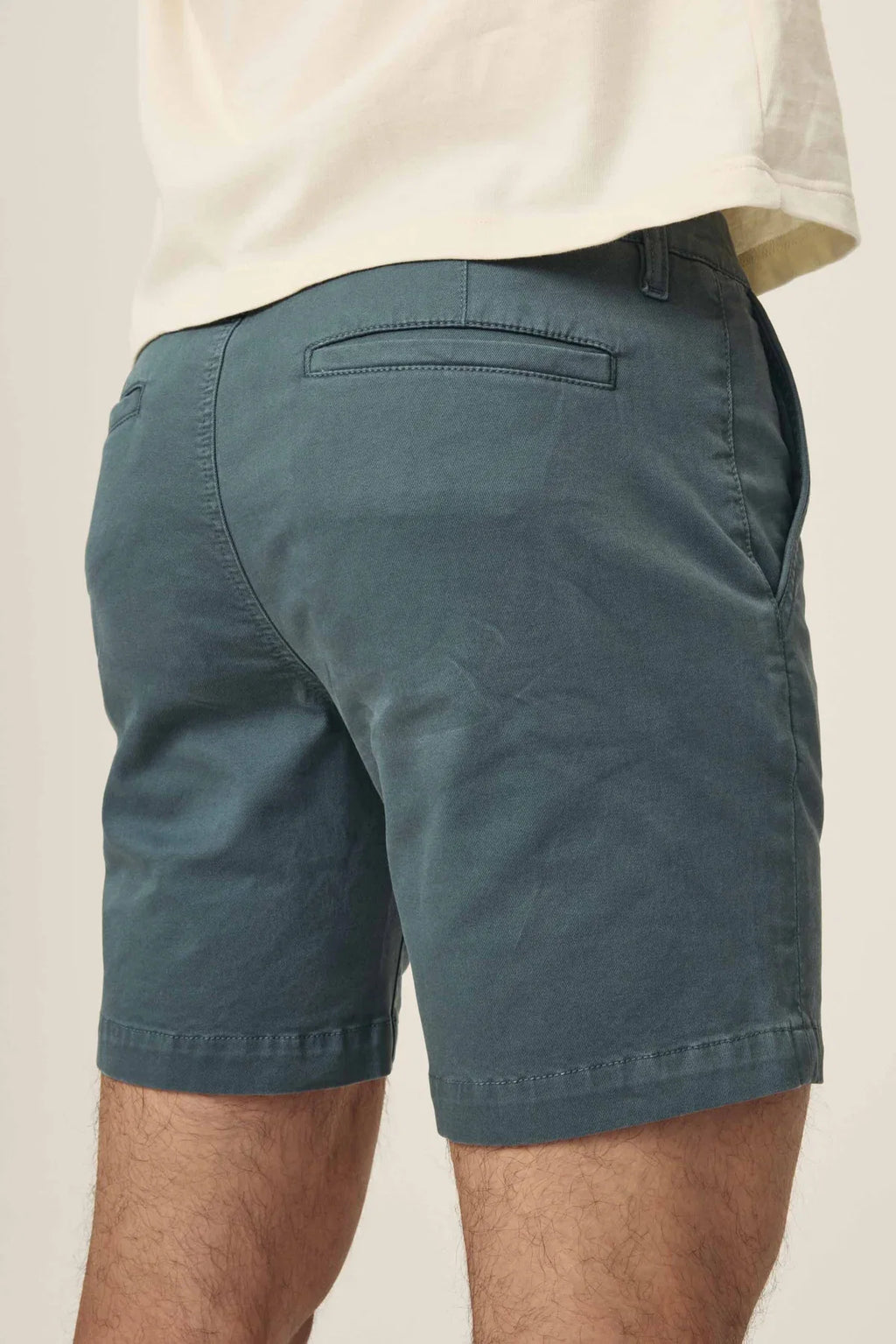 Rear view of Warp + Weft Denim Act Chino Shorts in a dark teal-green color with back welt pockets.