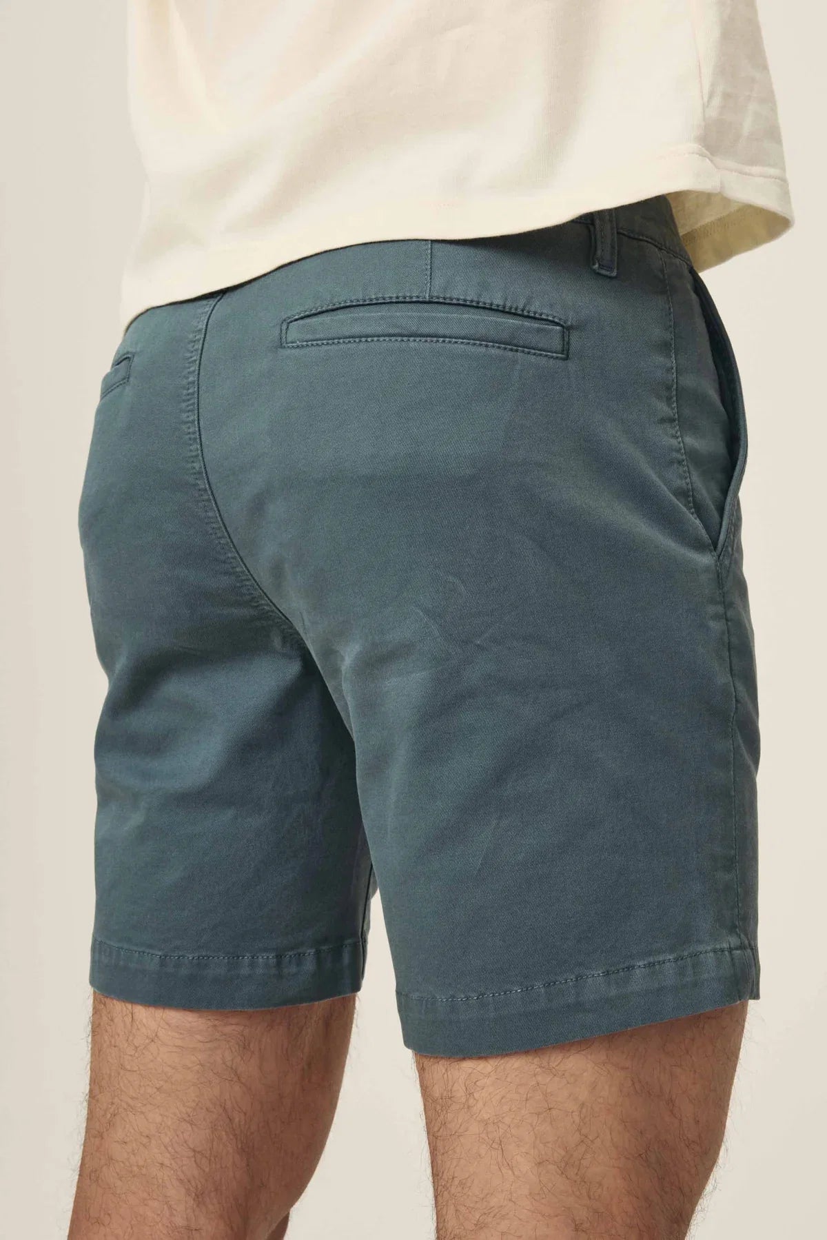Rear view of Warp + Weft Denim Act Chino Shorts in a dark teal-green color with back welt pockets.