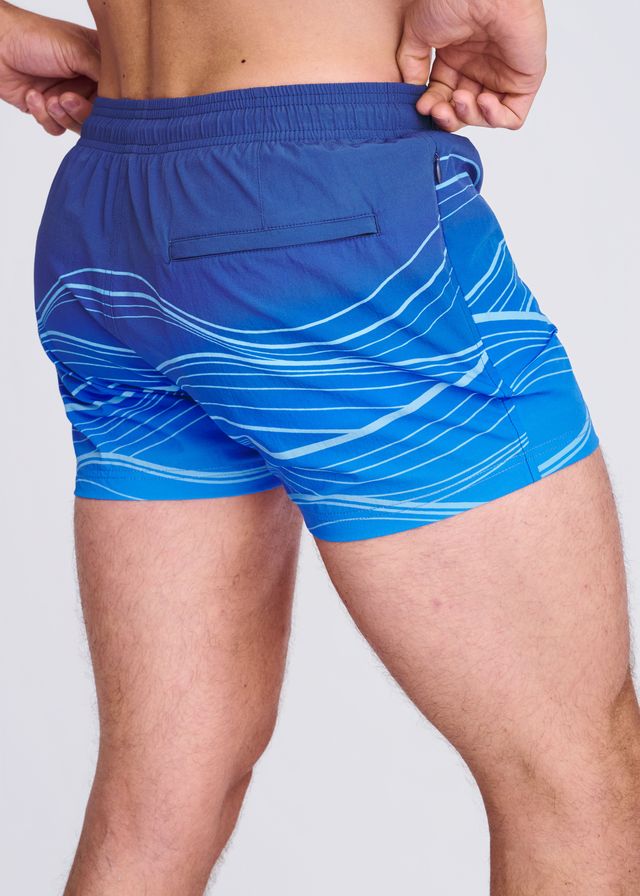 Blue swim shorts with white wavy line print and mesh lining designed for comfortable beach and pool use