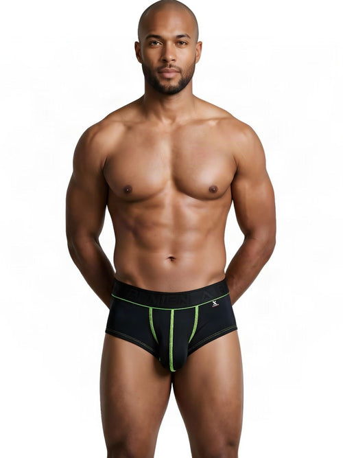 A shirtless man models Xtremen black trunks with neon green contrast stitching against a plain white background.