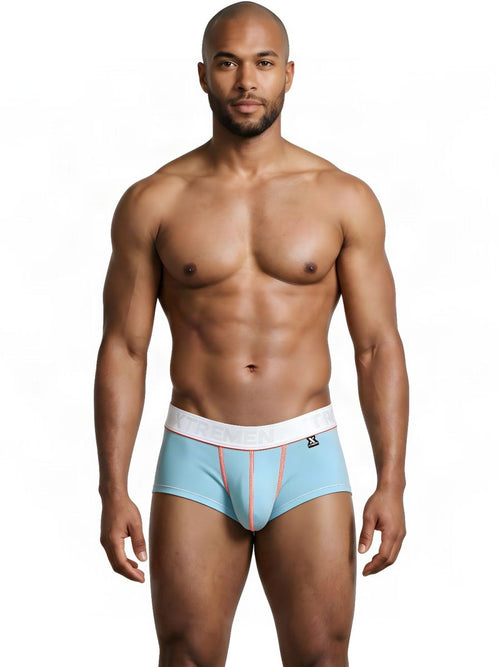 An athletic man models light blue Xtremen trunks with a white waistband and orange contrast stitching.