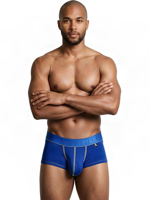 Man with arms crossed wears royal blue Xtremen microfiber trunks with contrasting stitching.