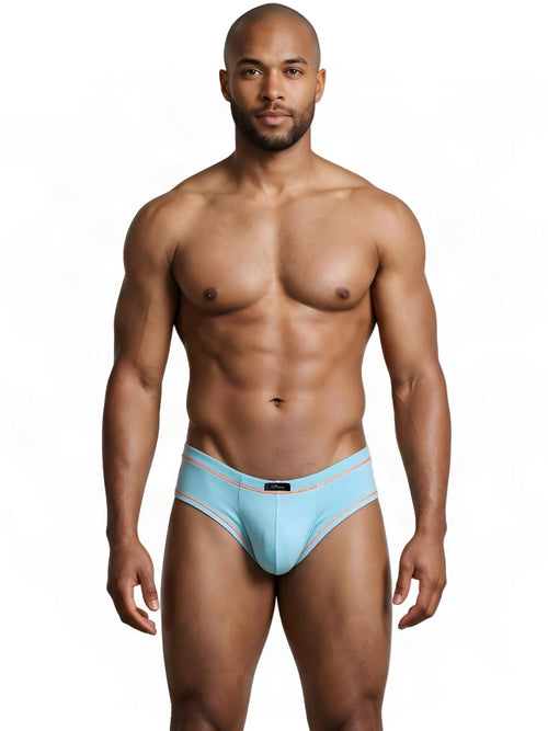 A man models light blue Xtremen athletic briefs with orange contrast stitching on a plain white background.