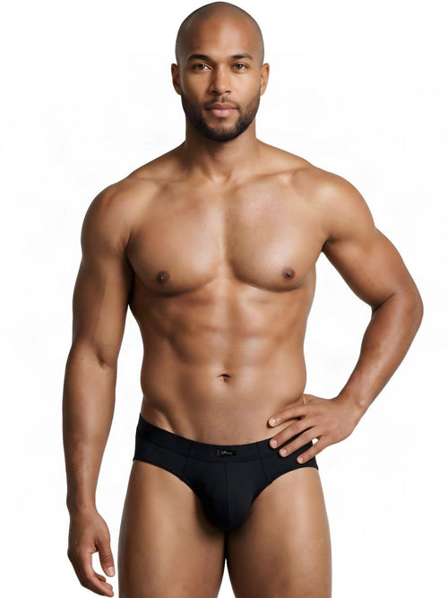 A muscular man modeling black Xtremen microfiber sleek fit briefs against a plain white background.