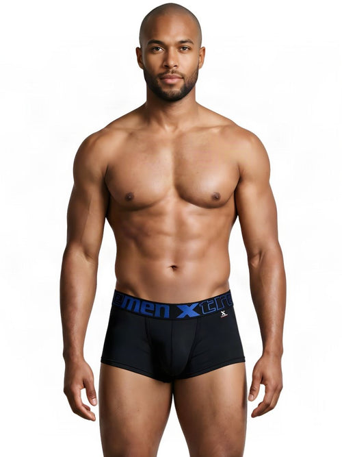 A shirtless man standing and wearing black Xtremen microfiber trunks with a blue logo waistband.