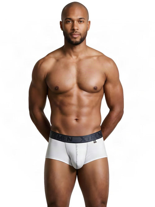 Man wearing Xtremen white athletic briefs with a branded dark waistband against a plain background.