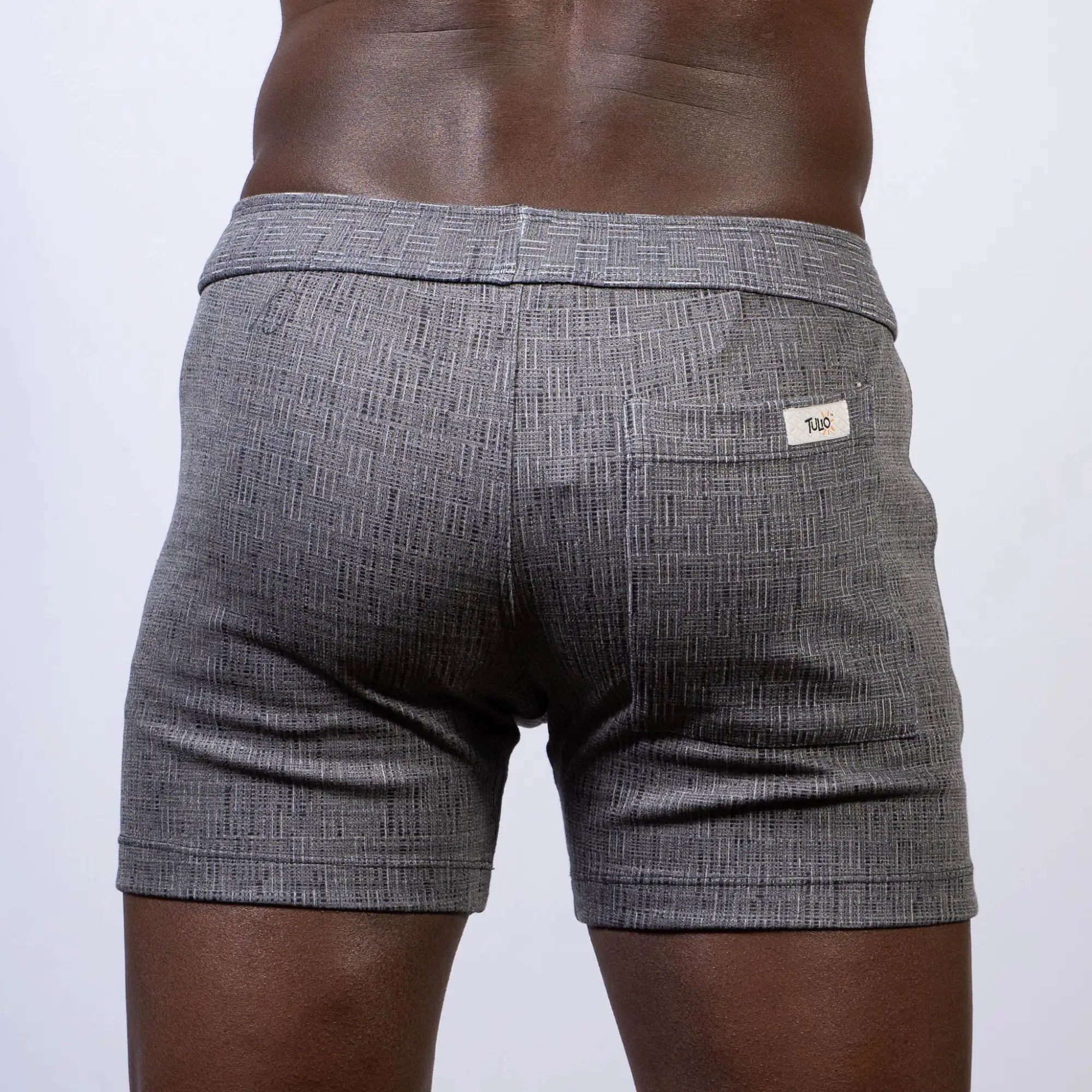 Gray abstract linen texture shorts with subtle herringbone pattern and white brand tag on back waistband visible