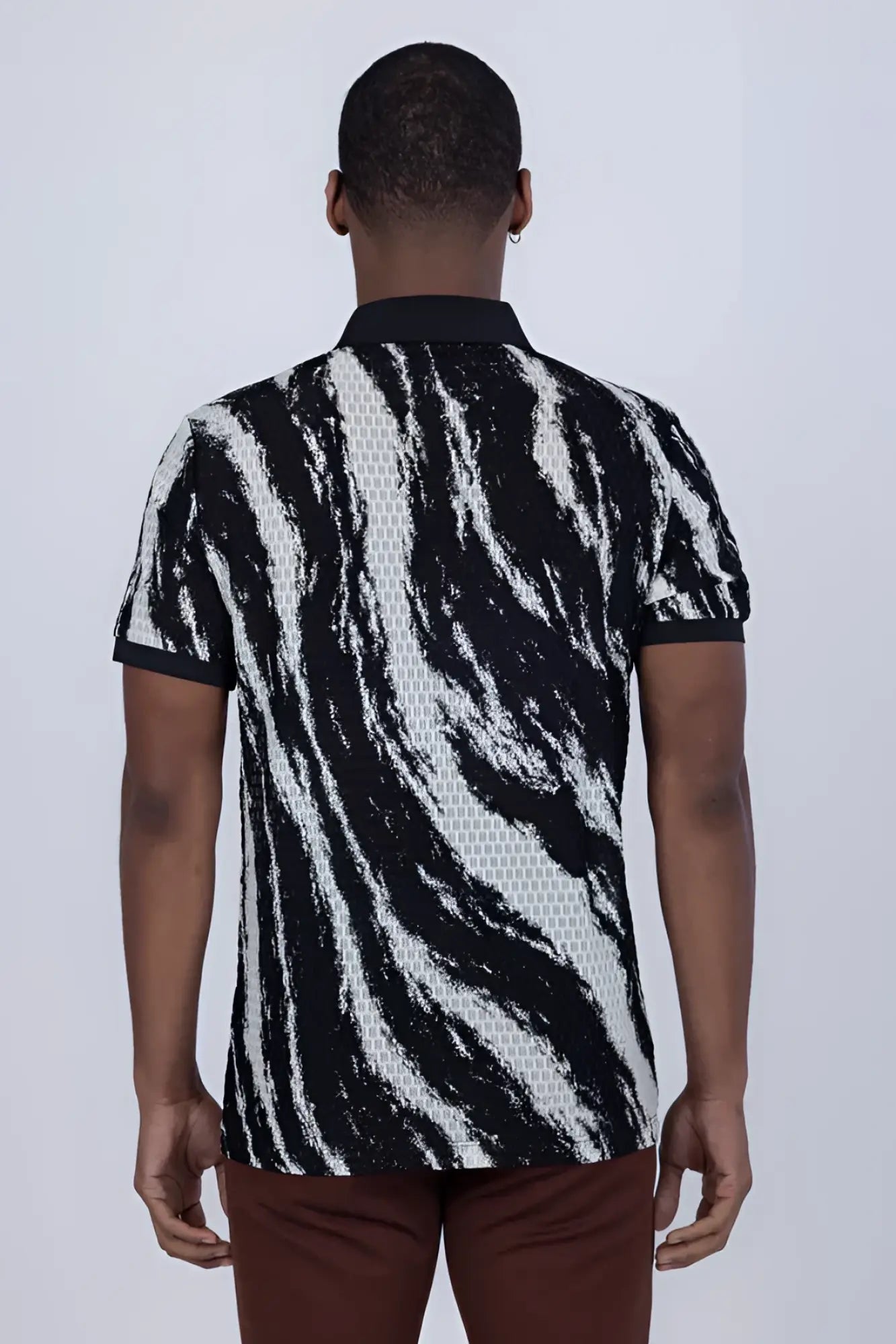 Black and white zebra-striped abstract polo shirt with textured woven pattern made from breathable fabric
