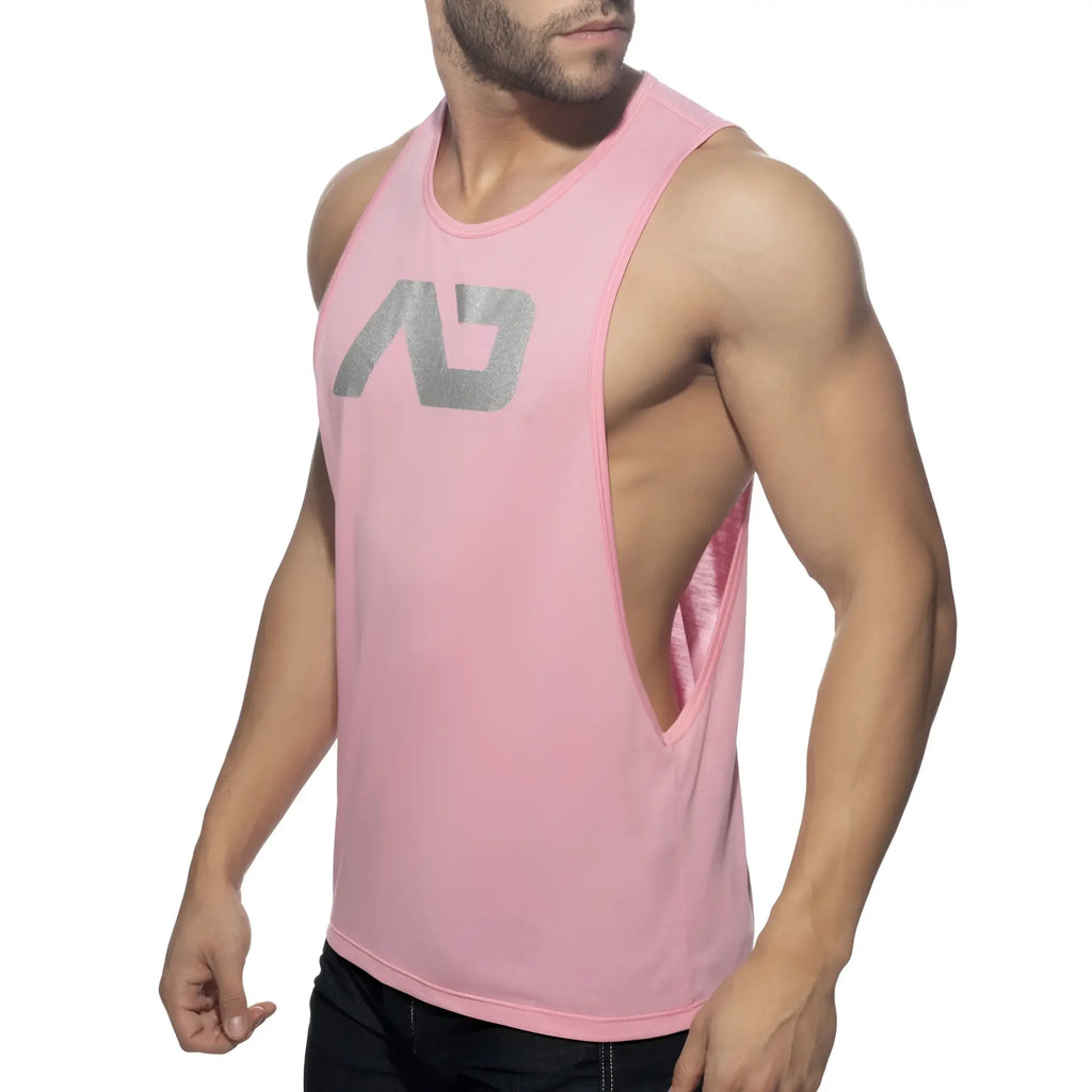 Pink sleeveless athletic tank top with silver ad logo and side cutout designed for low rider fit