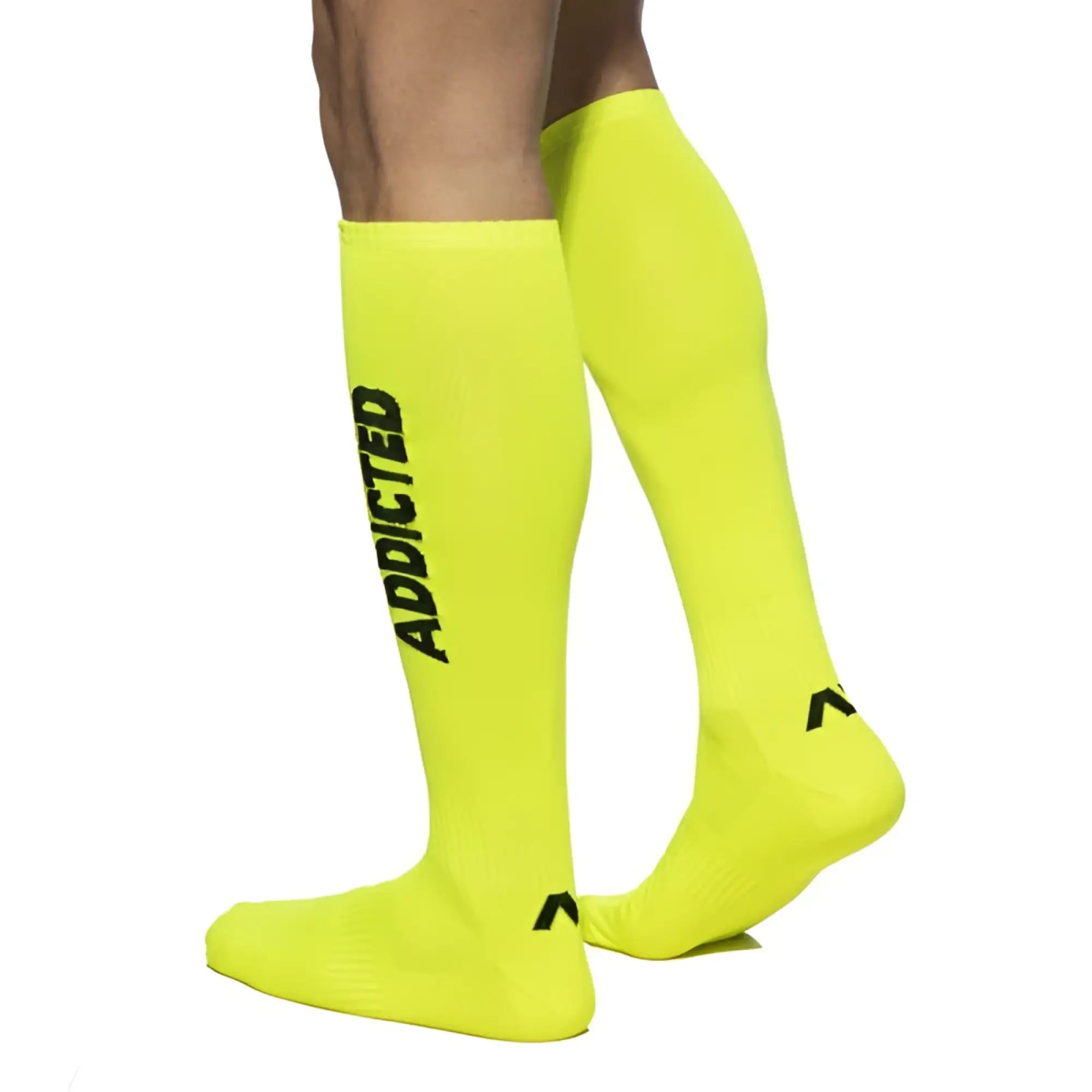 Bright neon yellow knee-high addicted socks with black lettering and a small logo on the foot for bold style