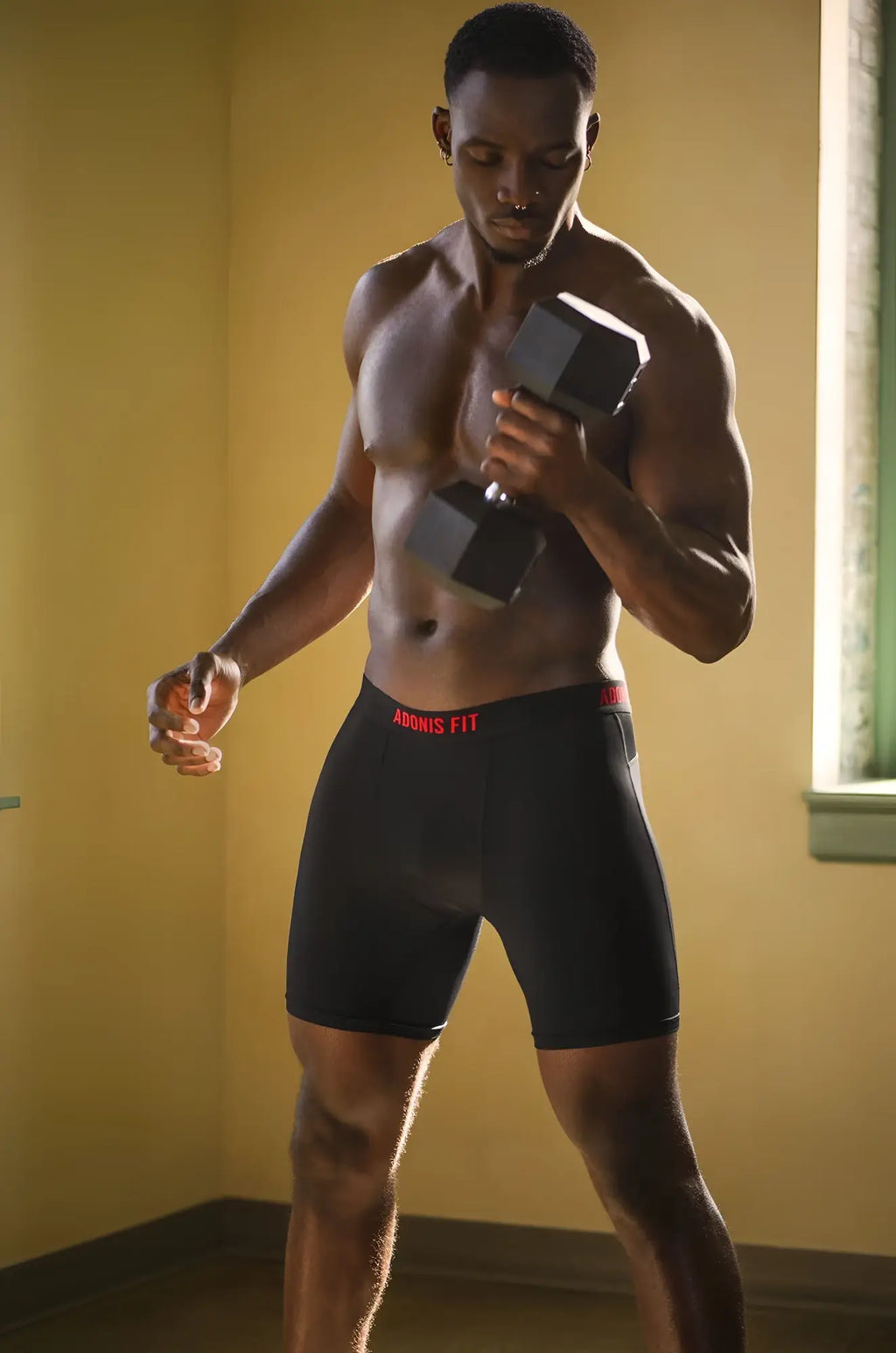 Black athletic briefs with red adonis fit branding on waistband designed for performance and comfort