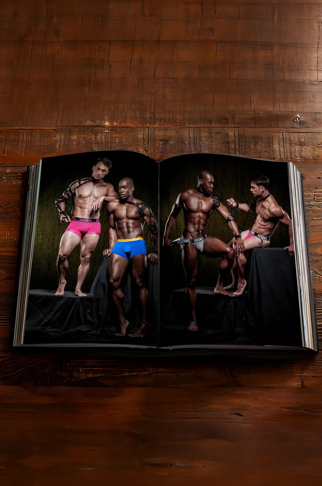 Open hardcover photobook adonis x a decade in images featuring four muscular men in colorful underwear photoshoot
