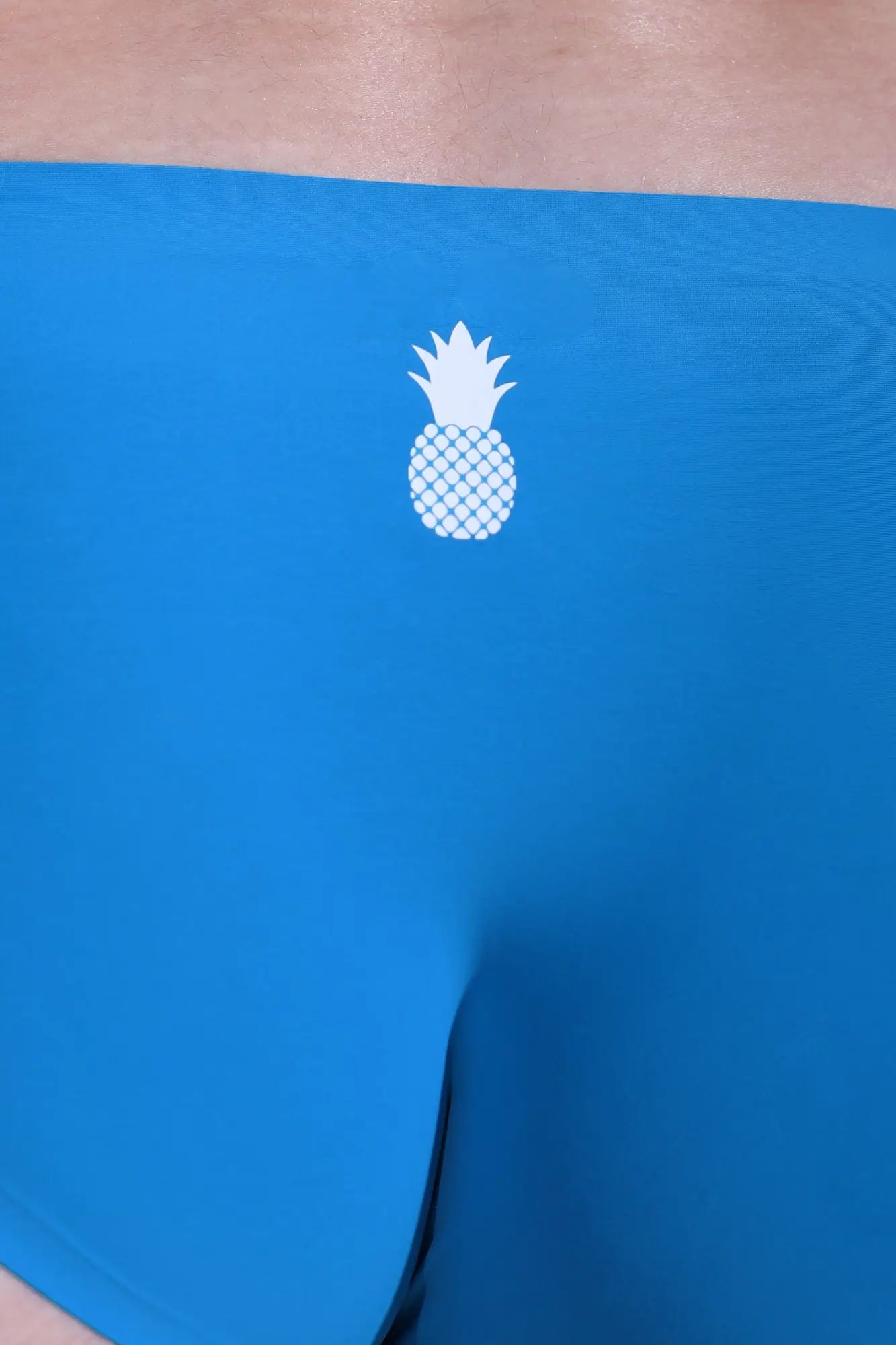 After-hours silky seamless briefs neon blue featuring a white pineapple logo with a diamond-patterned body