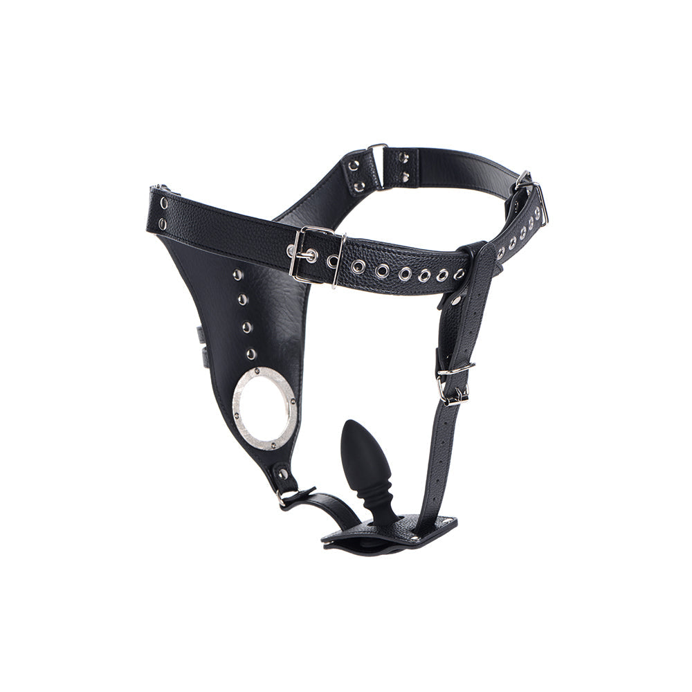Black leather strict male chastity harness with silver hardware and an attached black silicone anal plug.