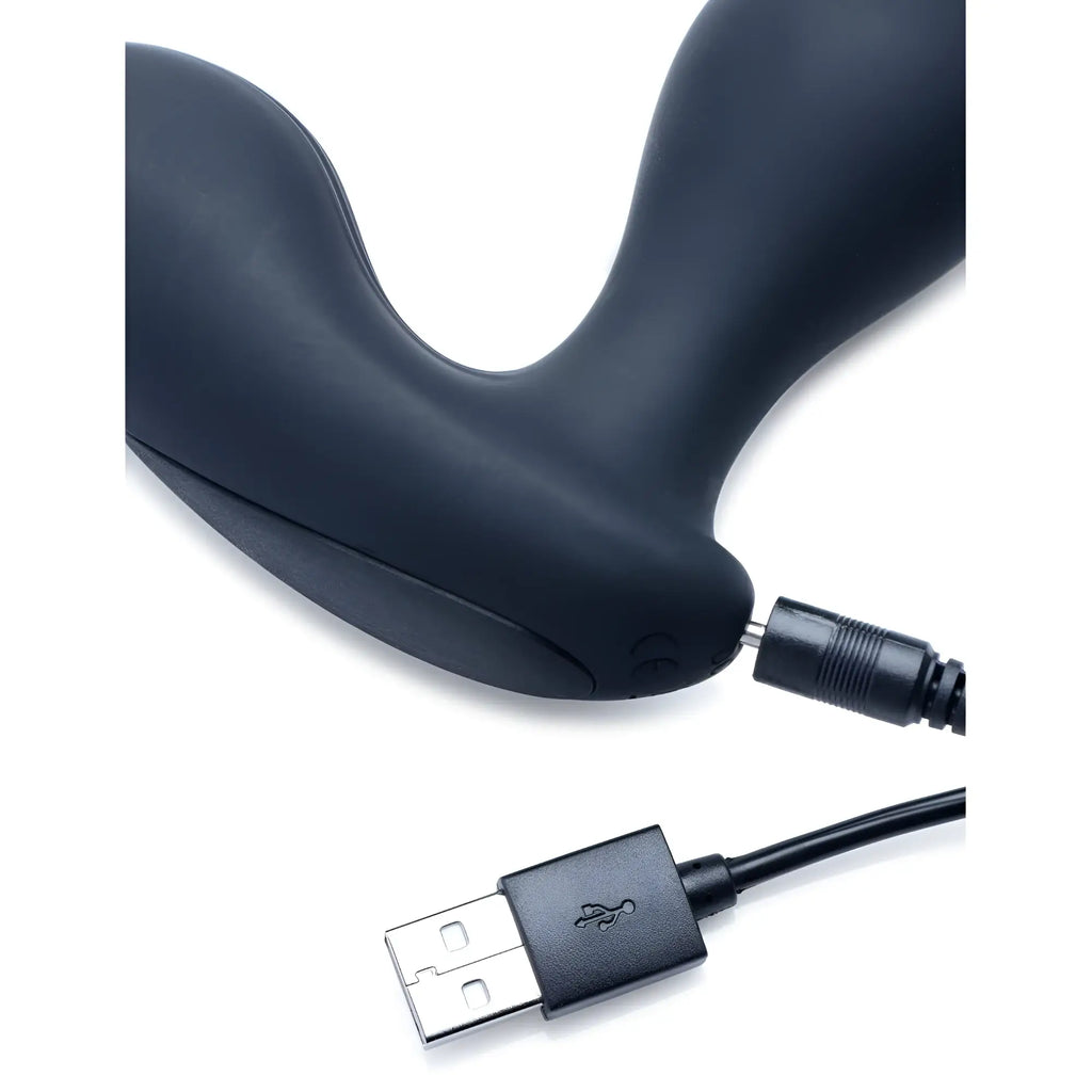 Alpha Pro 7X P-Gyro matte black silicone prostate stimulator connected to a USB charging cable on a white background.