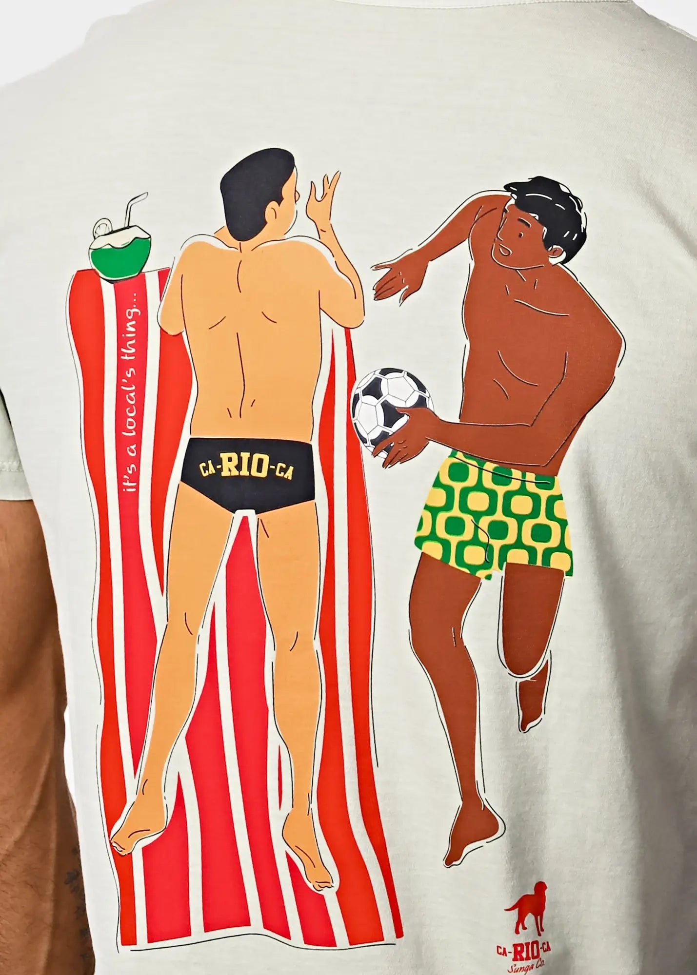 Off-white amigos men’s t-shirt with vibrant graphic of two men playing soccer in swim trunks by towel