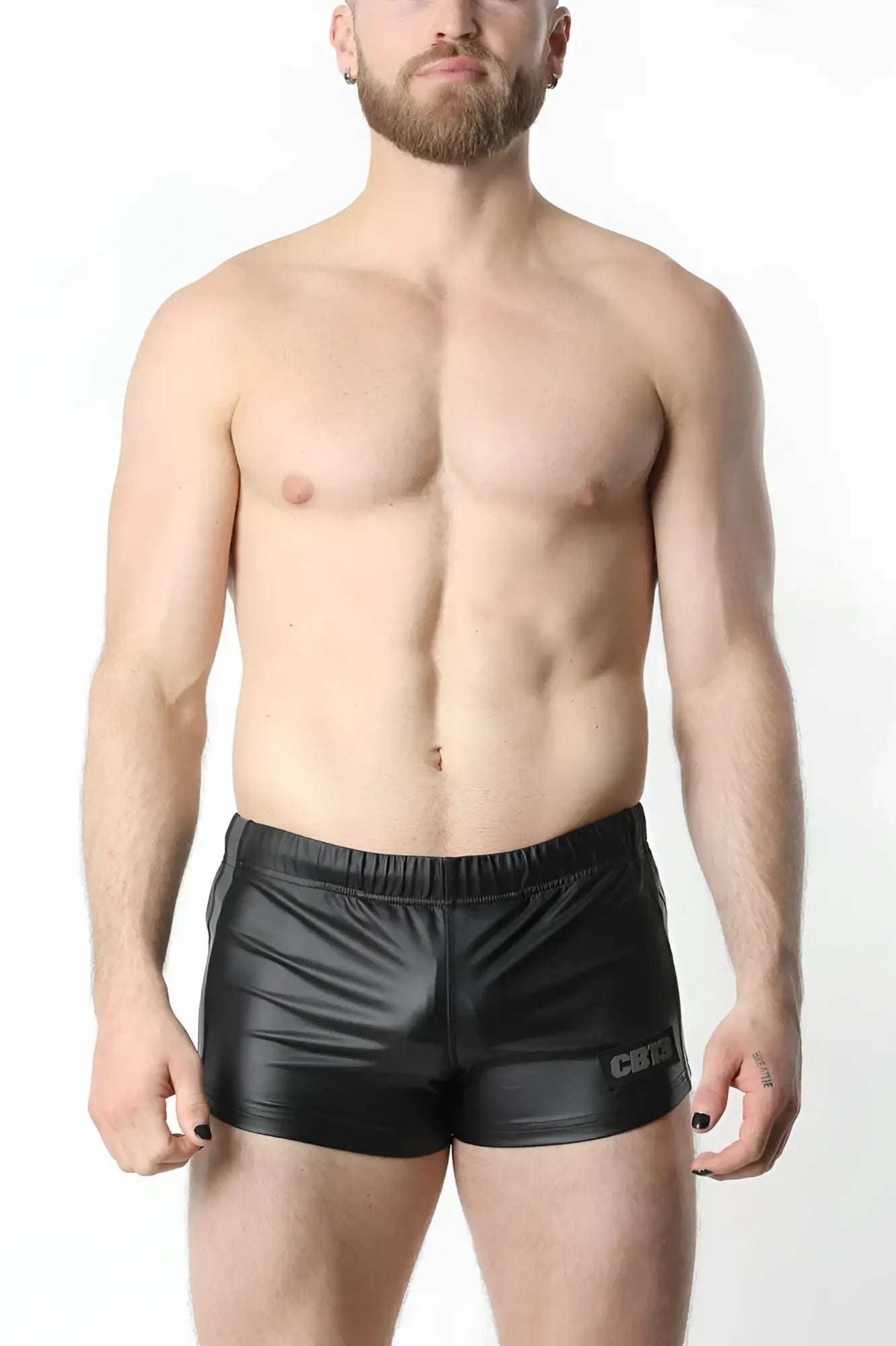 Black shiny faux leather ANTI-CHROME GEAR shorts with a subtle logo on the lower right leg