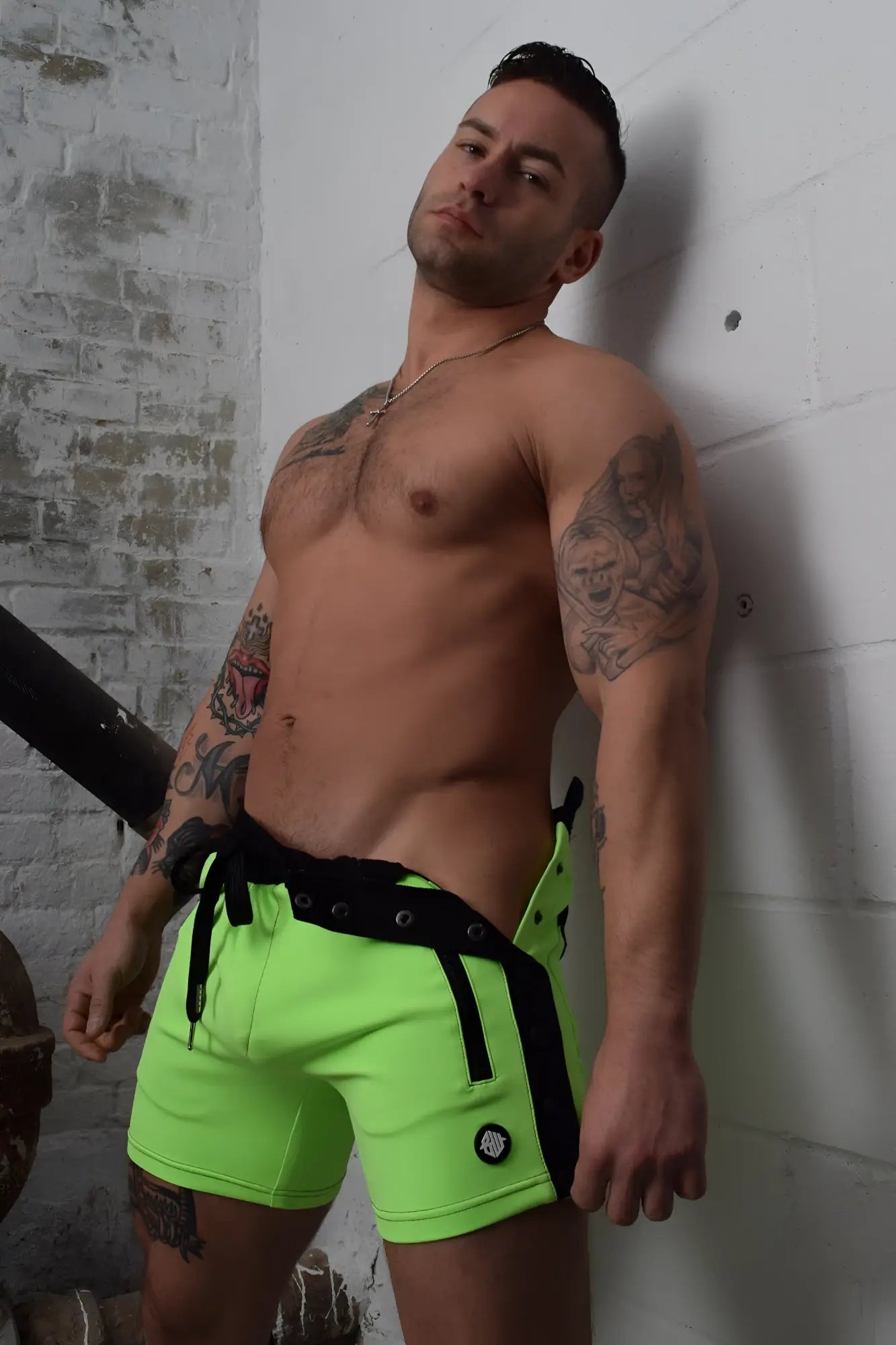 Neon green backpack shorts with black side panels and matching drawstring belt for athletic wear
